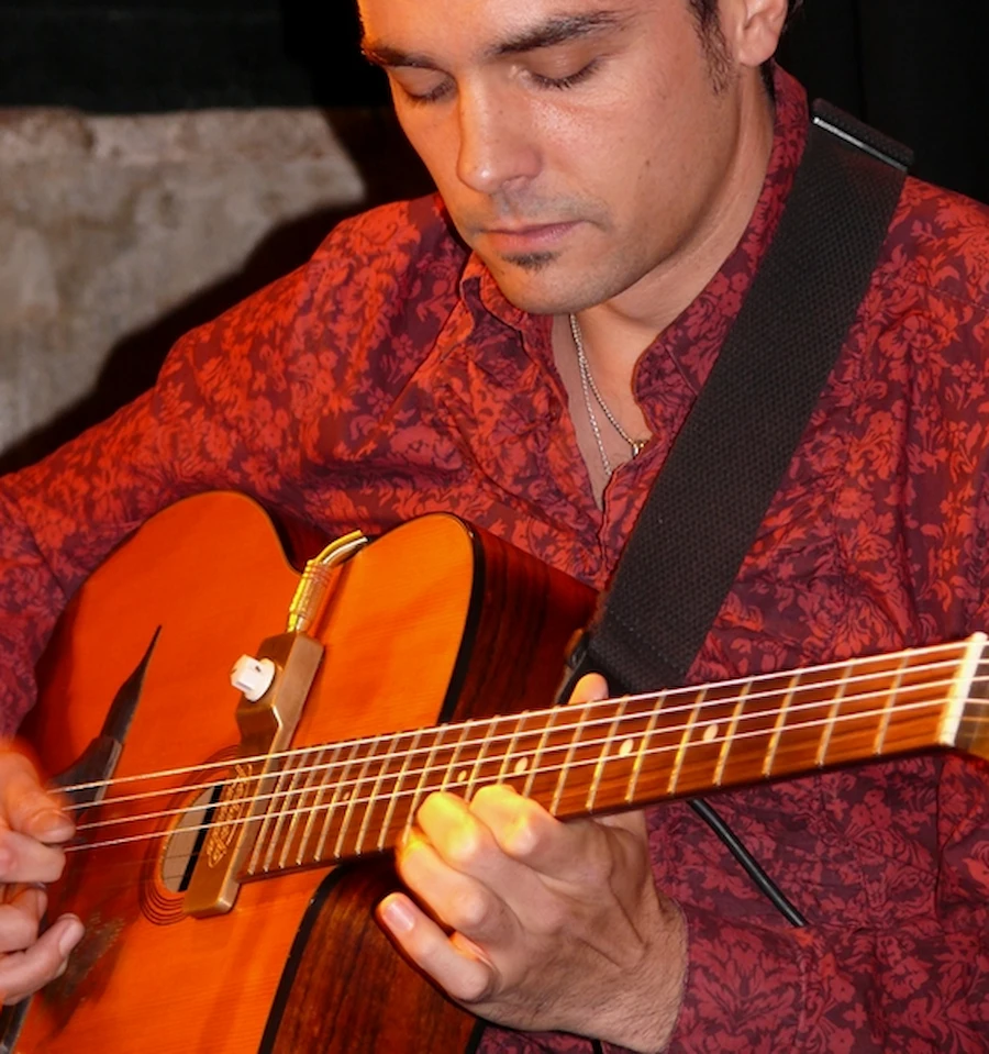 Gros plan sur Cyrille jouant de la guitare